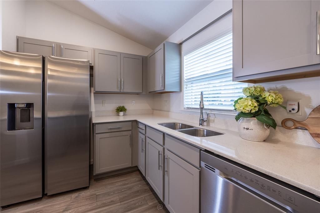 A kitchen features gray cabinets, stainless steel appliances, and white countertops — 196 FRONTIER DRIVE, PALM COAST, FL