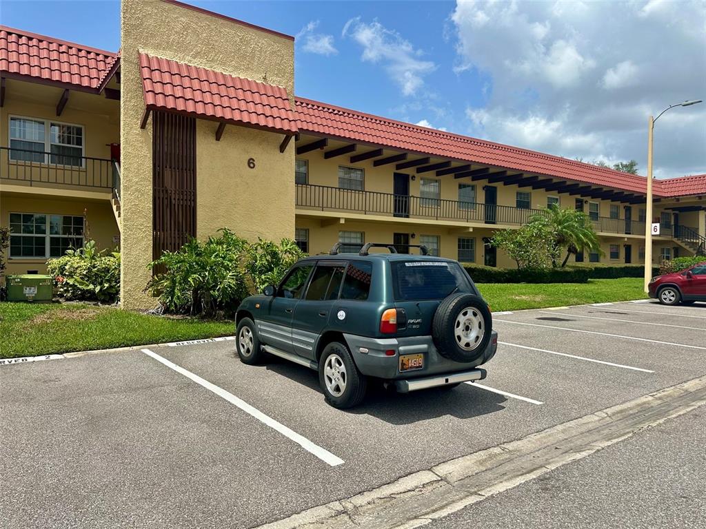 A dark green SUV is parked in front of a two-story apartment building — 1845 S HIGHLAND AVENUE UNIT 6-11, CLEARWATER, FL