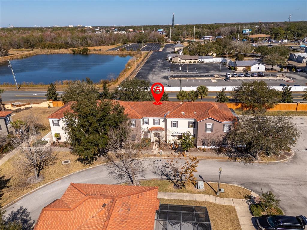 An aerial view shows a two-story building with a red tile roof and parking lot — 4554 ALBERTO CIRCLE, KISSIMMEE, FL