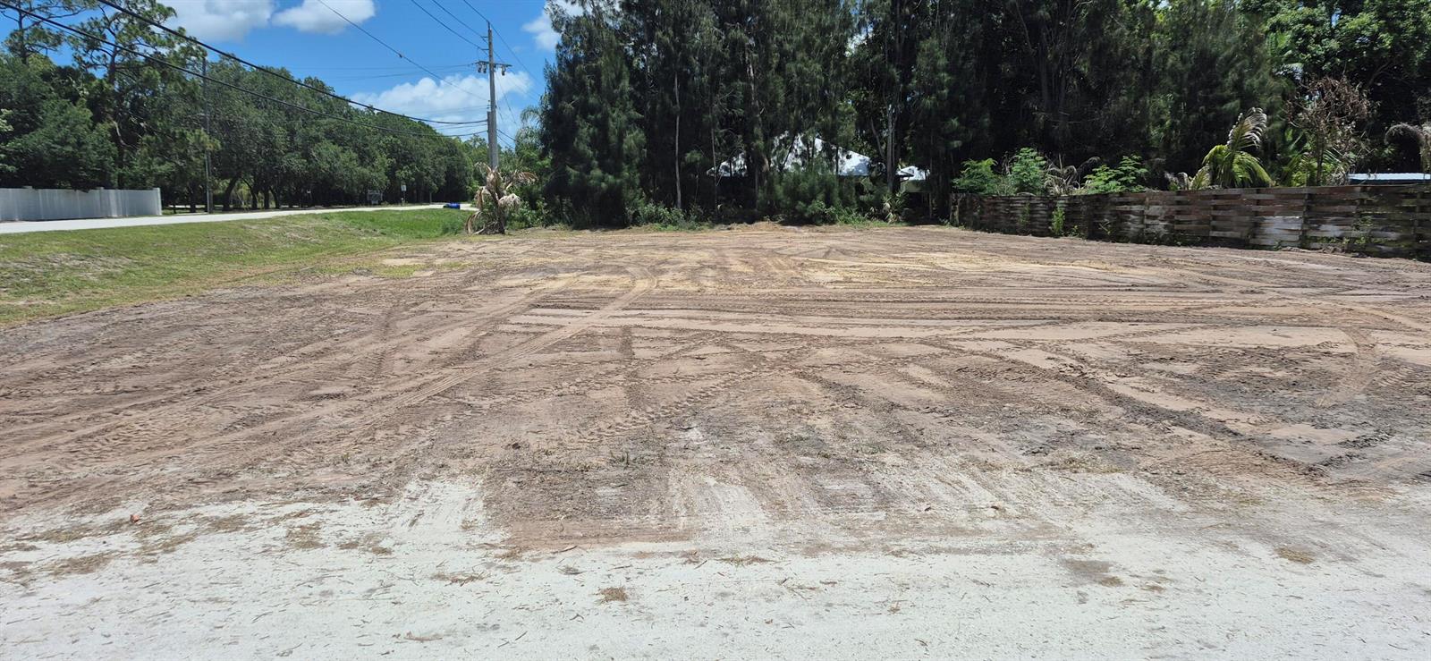A cleared, flat, sandy lot with tire tracks and a wooden fence in the background — 2346 SW 96th Street, Stuart FL 34997, STUART, FL