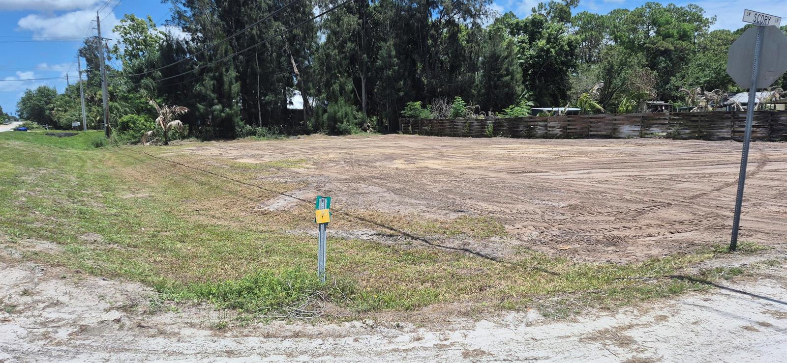 A cleared, vacant dirt lot sits at a street corner with a wooden fence behind it — 2346 SW 96th Street, Stuart FL 34997, STUART, FL