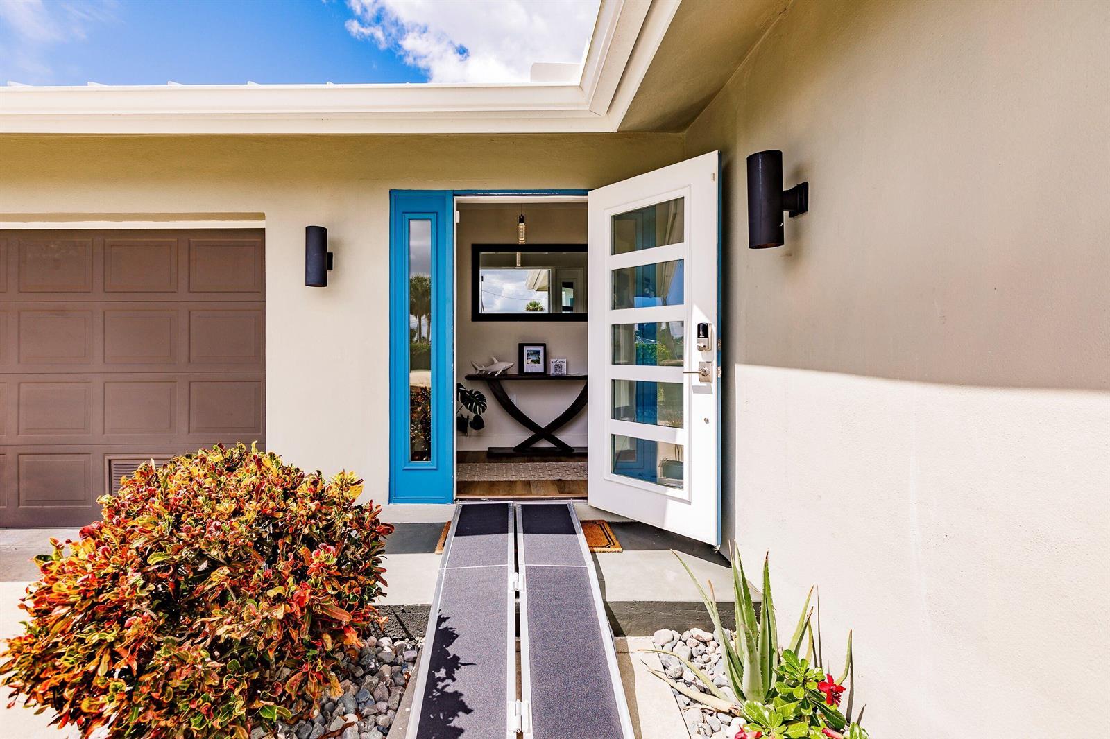 A house exterior features a white front door with a ramp leading to the entryway — 131 Casa Lane, Punta Gorda FL 33950, PUNTA GORDA, FL
