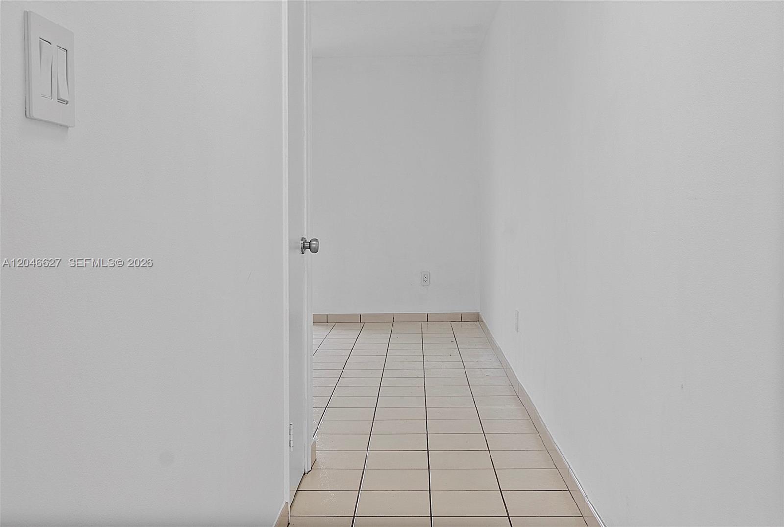 A doorway leads into a small, empty room with white walls and light-colored tile flooring — 10112 SW 23rd St, Miami FL 33165, MIAMI, FL