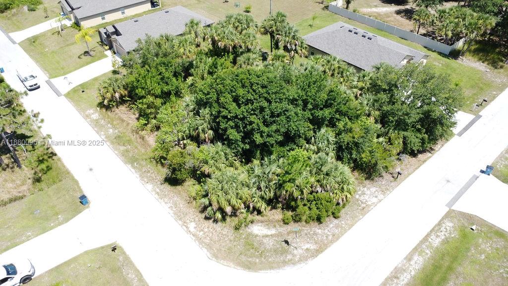 An aerial view shows a vacant, tree-covered lot situated between two residential houses — 0 0, Palm Bay FL 32908, PALM BAY, FL