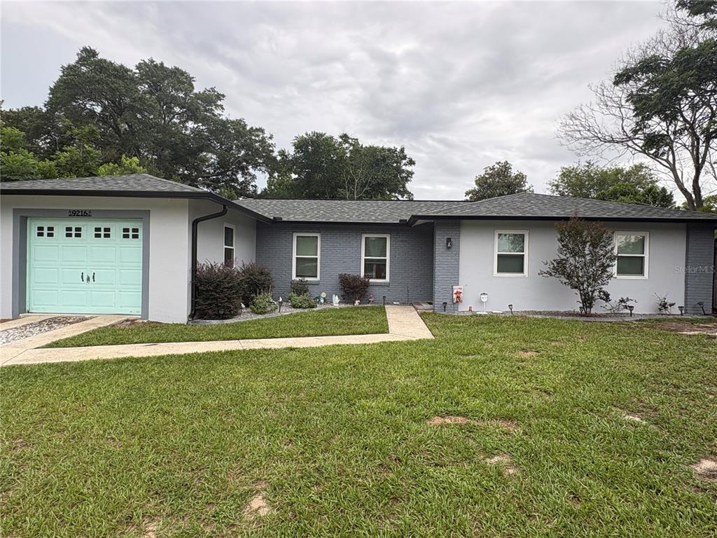 A single-story house with a gray brick and stucco exterior and a light green garage door — 9216 N ABBOT DRIVE, CITRUS SPRINGS, FL