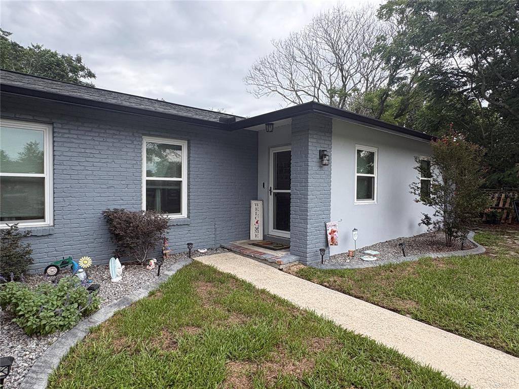 A gray brick house with a white front door and a concrete walkway — 9216 N ABBOT DRIVE, CITRUS SPRINGS, FL