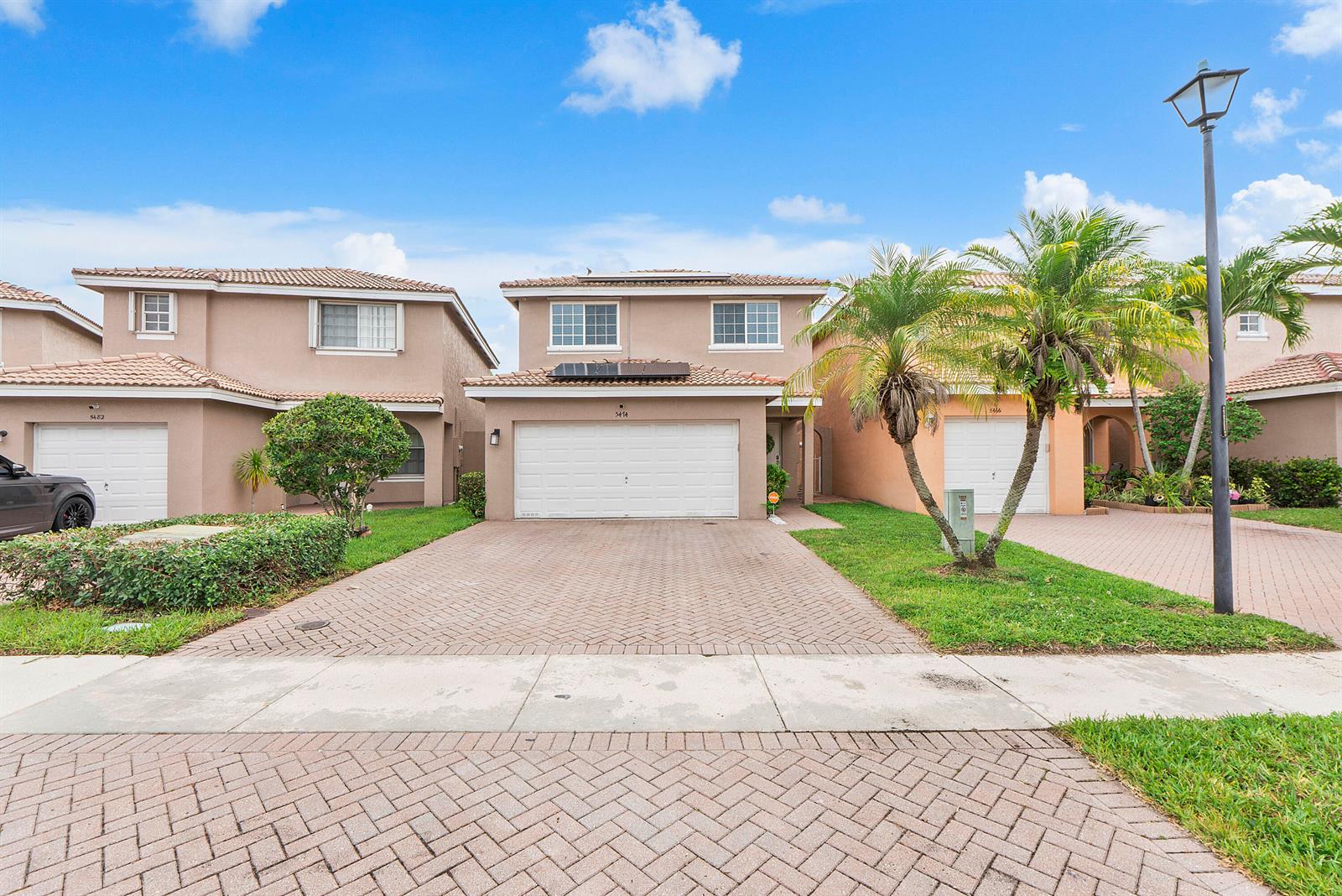 A two-story suburban house with a paved driveway, garage, and palm trees in the front — 5474 NW 94th Terrace, Sunrise FL 33351, SUNRISE, FL