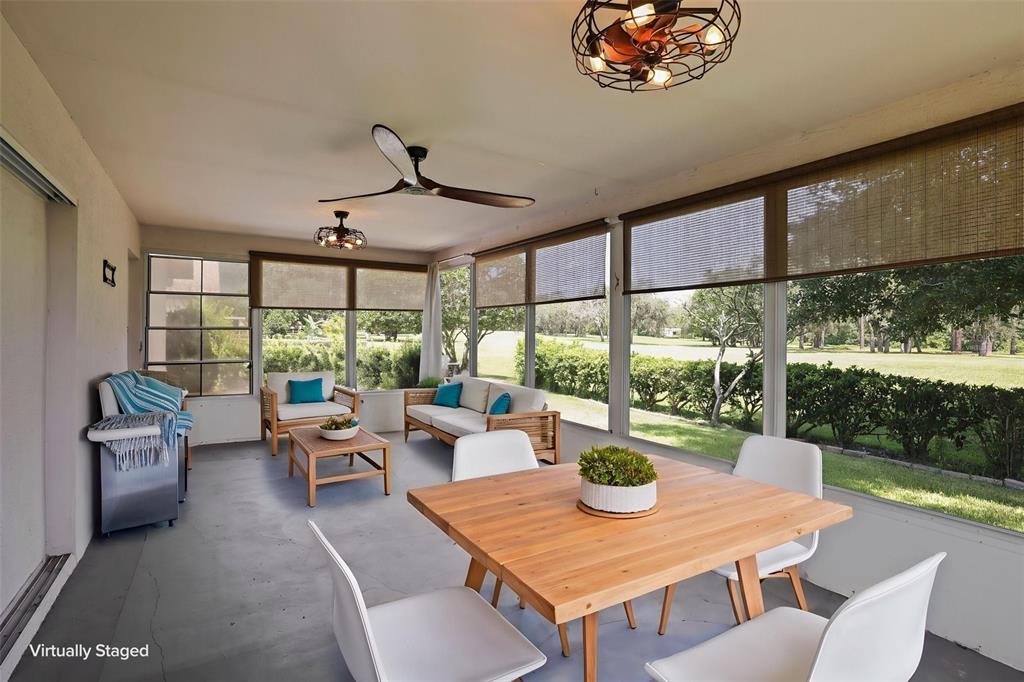 A screened-in patio features a dining set, lounge furniture, and views of a grassy yard — 13200 TITLEIST DRIVE, HUDSON, FL