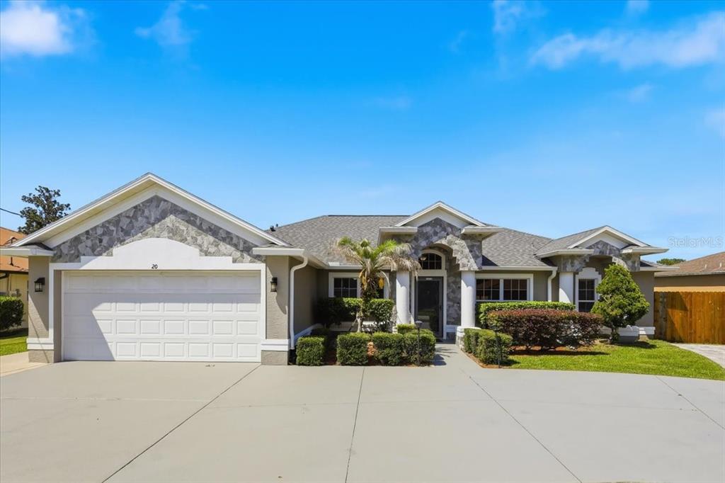 A single-story house with a stone-accented facade, a two-car garage, and a concrete driveway — 20 BUTTERNUT, PALM COAST, FL