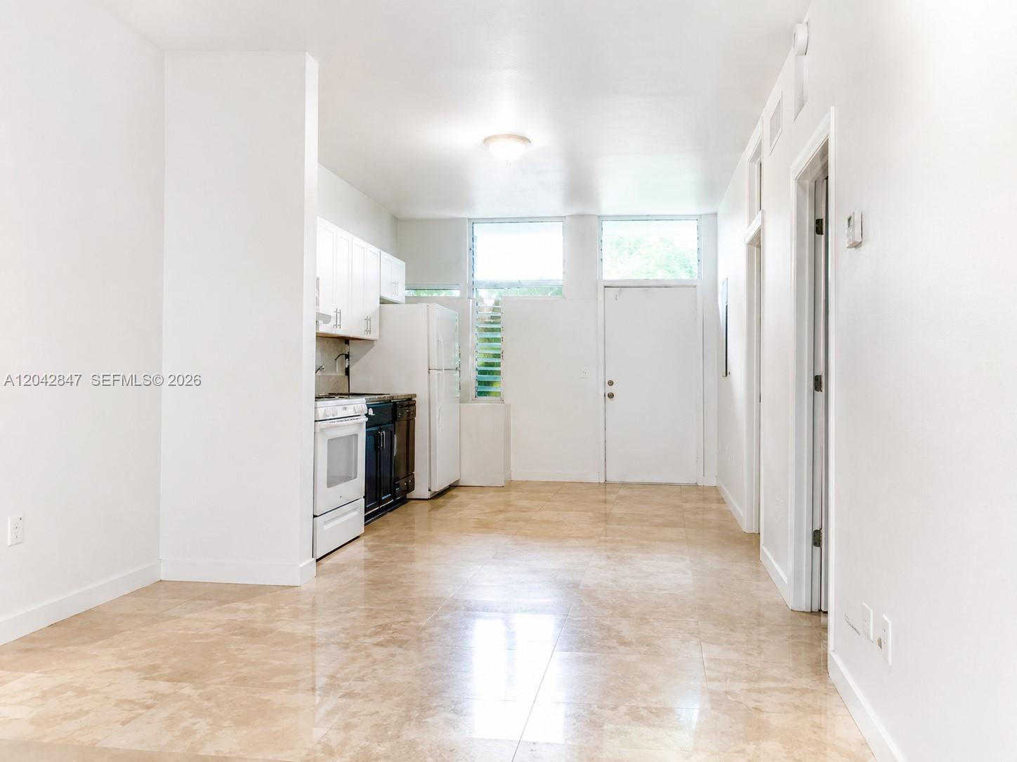 A white exterior wall borders a stone walkway and a wooden fence — 428 NW 82nd Ter # 426, Miami FL 33150, MIAMI, FL