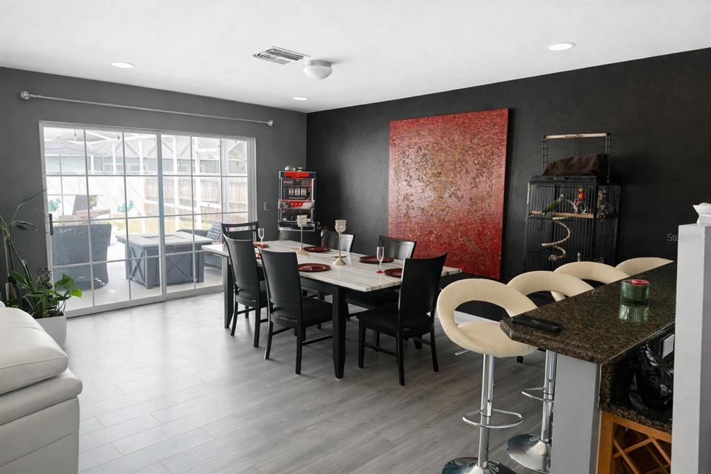A dining room with a marble table, black chairs, and a large red wall art piece — 3520 STABLE RIDGE LANE, LAND O LAKES, FL