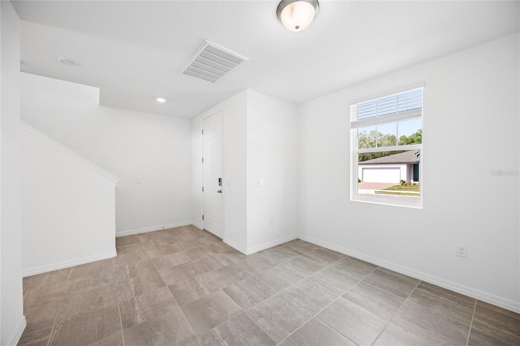 A bright room with white walls, tile flooring, a window, and a door to the exterior — 2339 WHITE TAIL, DAVENPORT, FL