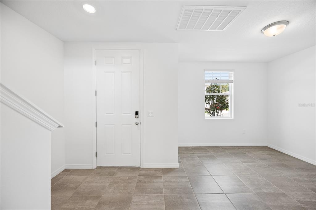 A white-walled room features a tiled floor, a white door, and a single window — 2339 WHITE TAIL, DAVENPORT, FL