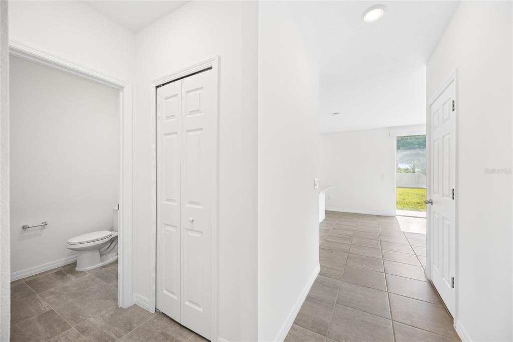 A hallway with tile flooring leads to a bathroom, a closet, and an open living area — 2339 WHITE TAIL, DAVENPORT, FL