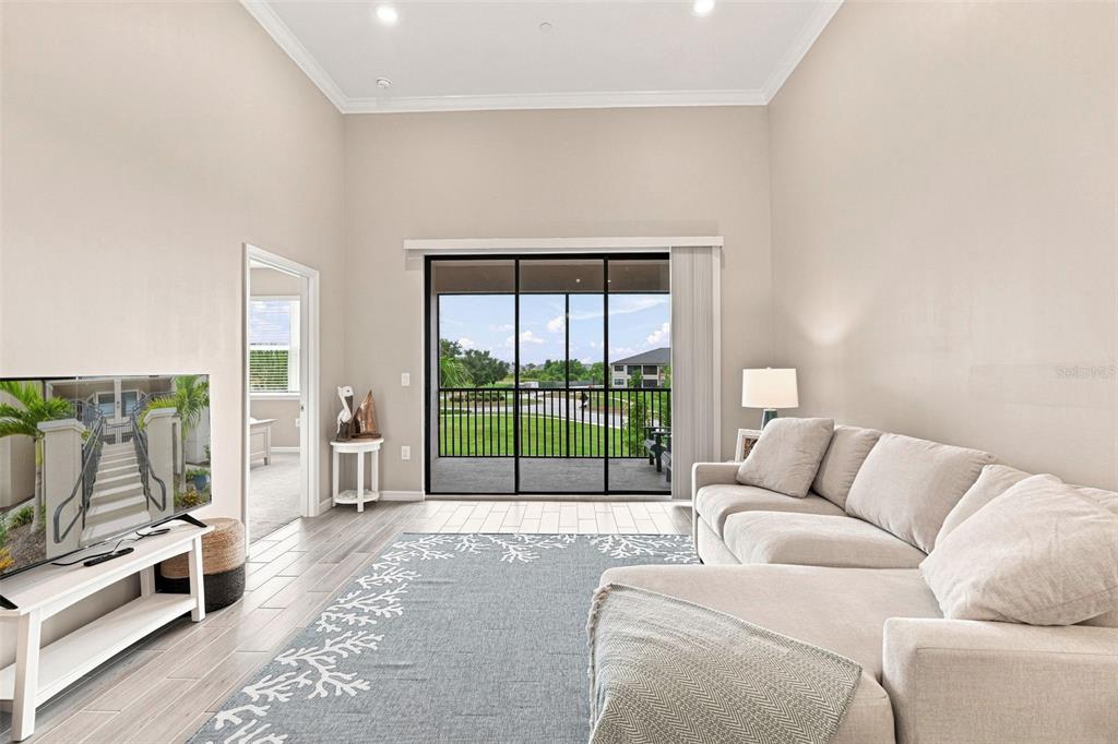 A two-story apartment building features tan stucco walls, brown shingled roofs, and exterior staircases — 23819 COLLINA WAY UNIT 203, PORT CHARLOTTE, FL