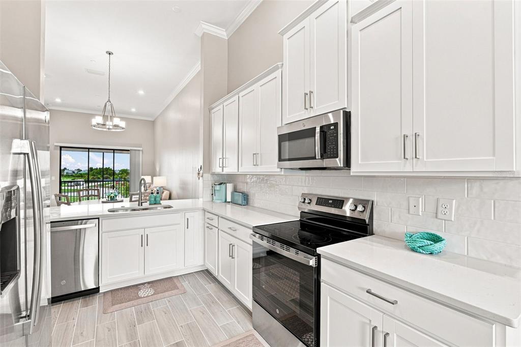 An aerial view shows a community clubhouse and swimming pool situated on a small island — 23819 COLLINA WAY UNIT 203, PORT CHARLOTTE, FL