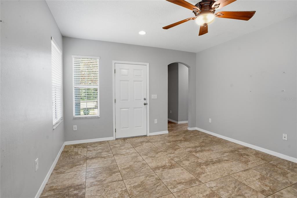 A room with light gray walls, tile flooring, a ceiling fan, and a white door — 9913 EDMONTON DRIVE, LAND O LAKES, FL