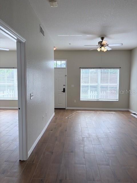 An interior view shows a living area with wood-look tile flooring and a ceiling fan — 2201 SAN VITTORINO CIRCLE UNIT 106, KISSIMMEE, FL