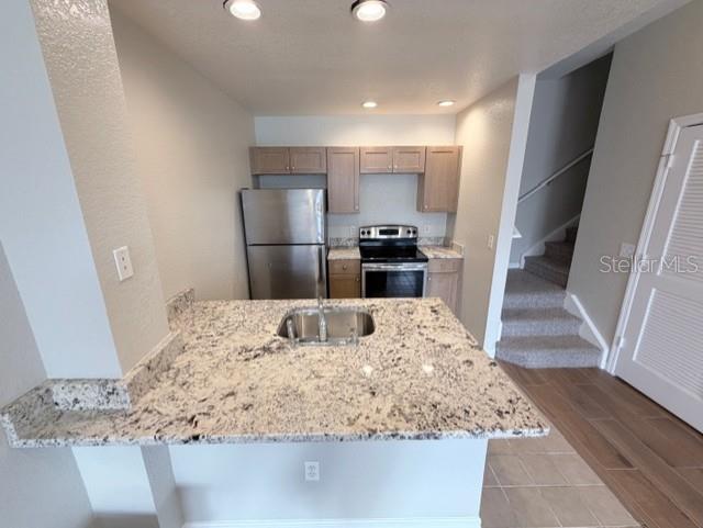 A kitchen features granite countertops, stainless steel appliances, and light wood cabinets — 2201 SAN VITTORINO CIRCLE UNIT 106, KISSIMMEE, FL