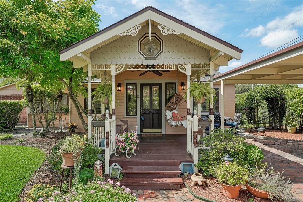 A charming front porch with a hanging chair, decorative trim, and a dark wood door — 1020 VENETIAN AVENUE, ORLANDO, FL