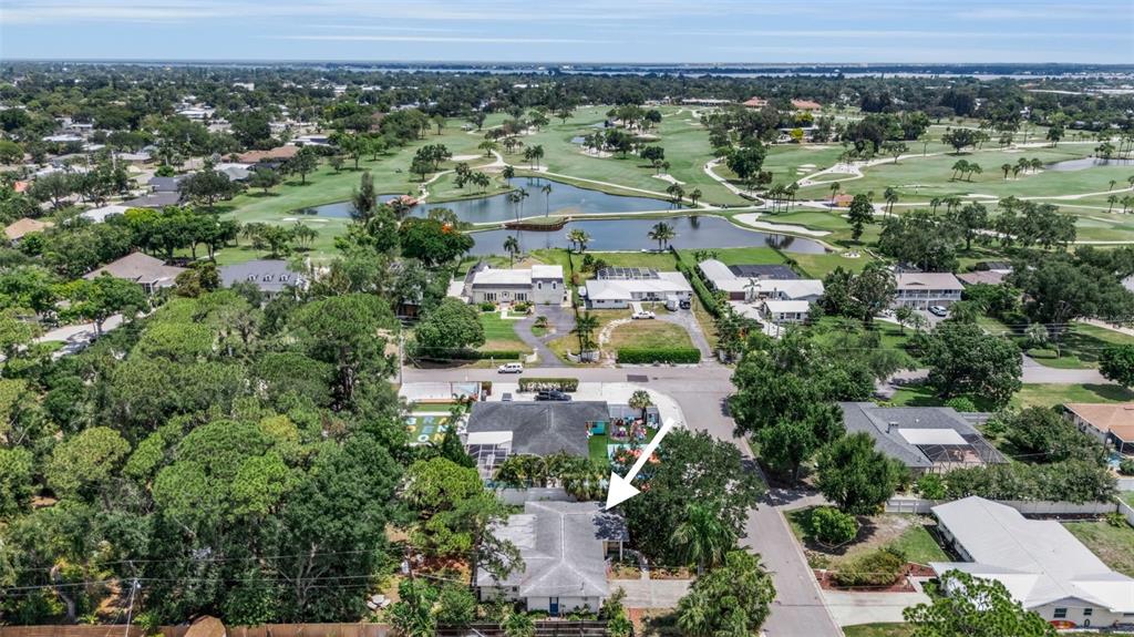 An aerial view shows a single-story house with a gray roof near a golf course — 1808 49TH STREET W, BRADENTON, FL