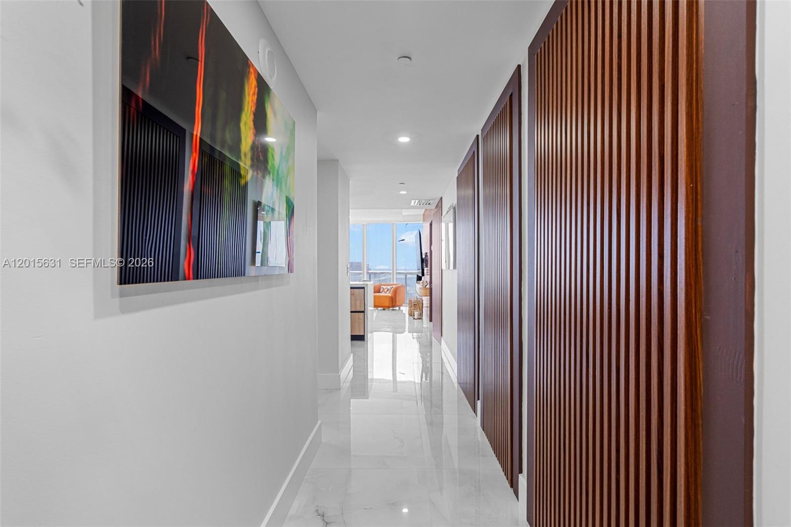 A hallway with white marble floors, a large abstract painting, and vertical wood slat walls — 465 Brickell Ave # 3301, Miami FL 33131, MIAMI, FL