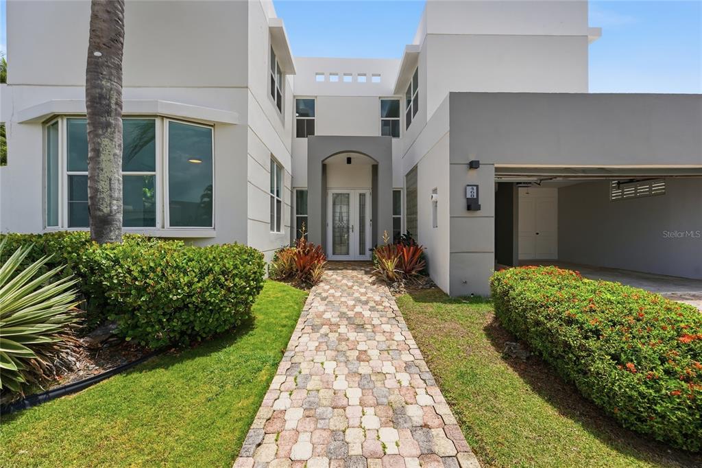 A two-story house features a paved walkway leading to a central arched entryway — 468 CALLE VIA MEDITERRANEA UNIT 468, DORADO, PR