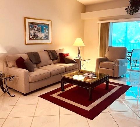 A living room features a beige sofa, a recliner, and a coffee table on a rug — 9480 HIGH GATE DRIVE UNIT 2125, SARASOTA, FL