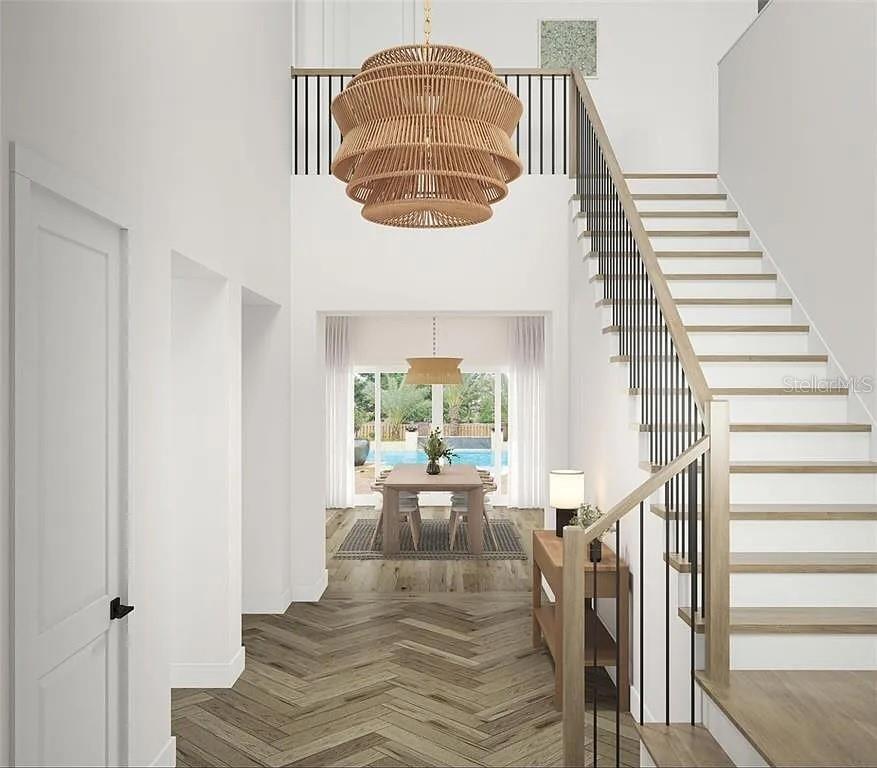 This rendering shows a bright entryway with a wooden chandelier, herringbone floors, and a staircase — 8151 36TH AVENUE N, ST PETERSBURG, FL