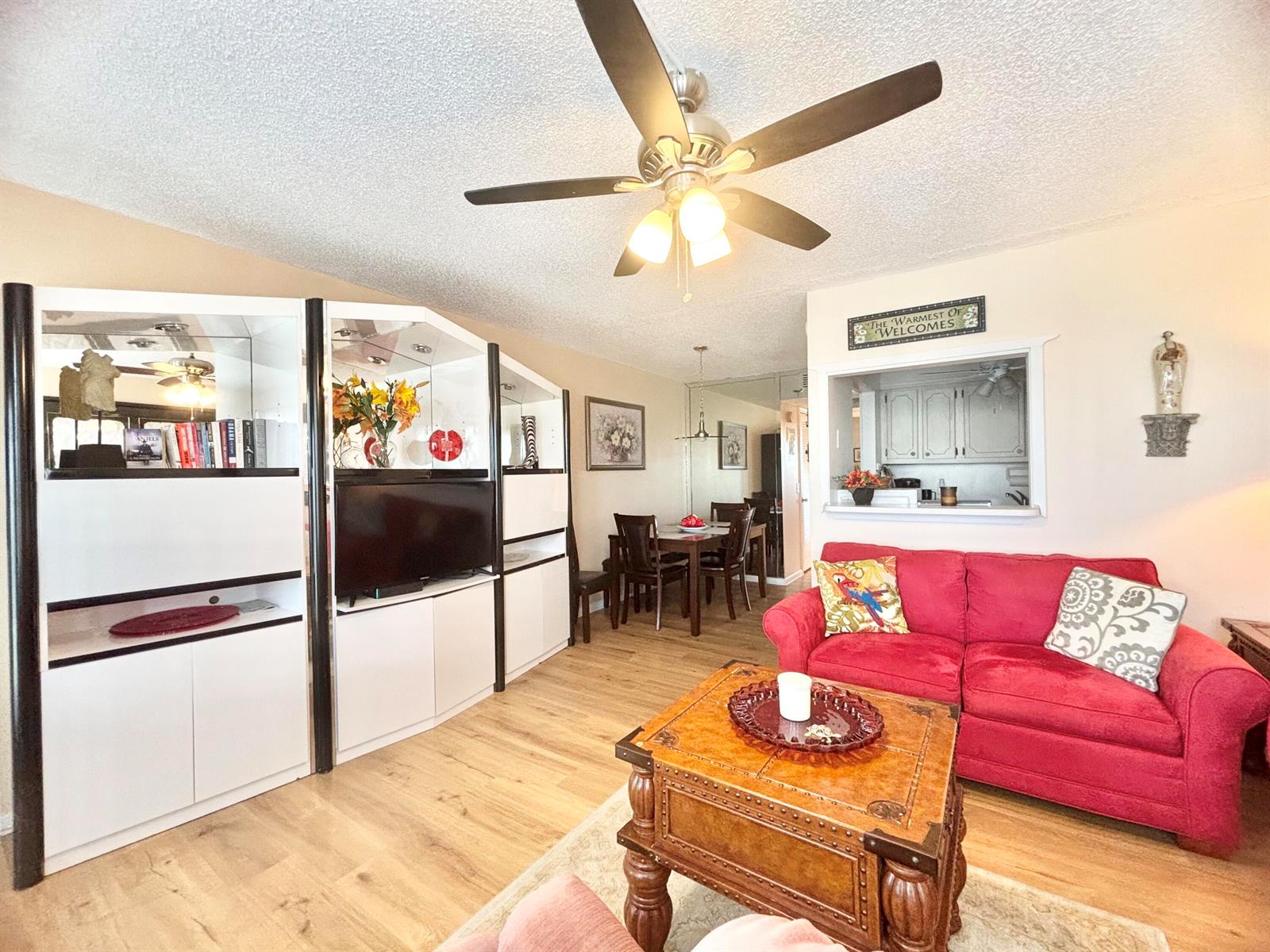 A living room features a red sofa, a wooden coffee table, and a white media unit — 4010 Harwood C # 4010, Deerfield Beach FL 33442, DEERFIELD BEACH, FL