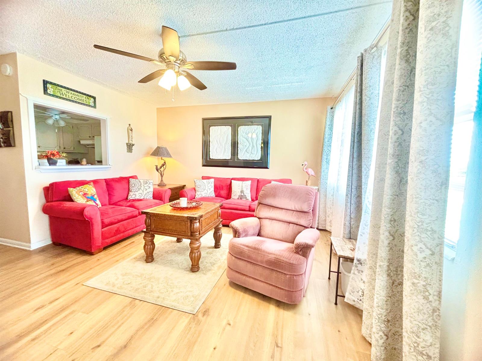 A living room features two red sofas, a pink recliner, and a wooden coffee table — 4010 Harwood C # 4010, Deerfield Beach FL 33442, DEERFIELD BEACH, FL