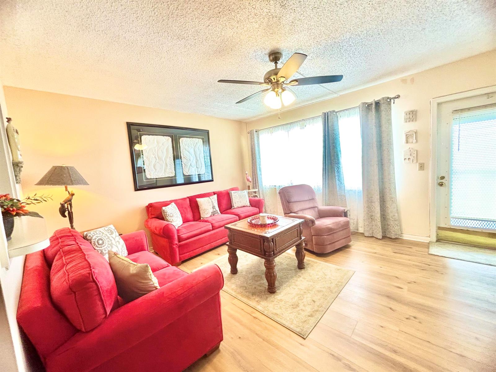 A living room features red sofas, a wooden coffee table, and a ceiling fan — 4010 Harwood C # 4010, Deerfield Beach FL 33442, DEERFIELD BEACH, FL