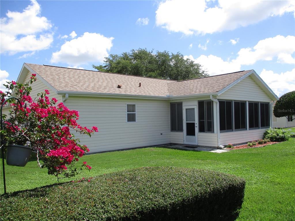 A light-colored house with a screened-in porch and a blooming bougainvillea bush in the yard — 11588 SW 139TH PLACE, DUNNELLON, FL