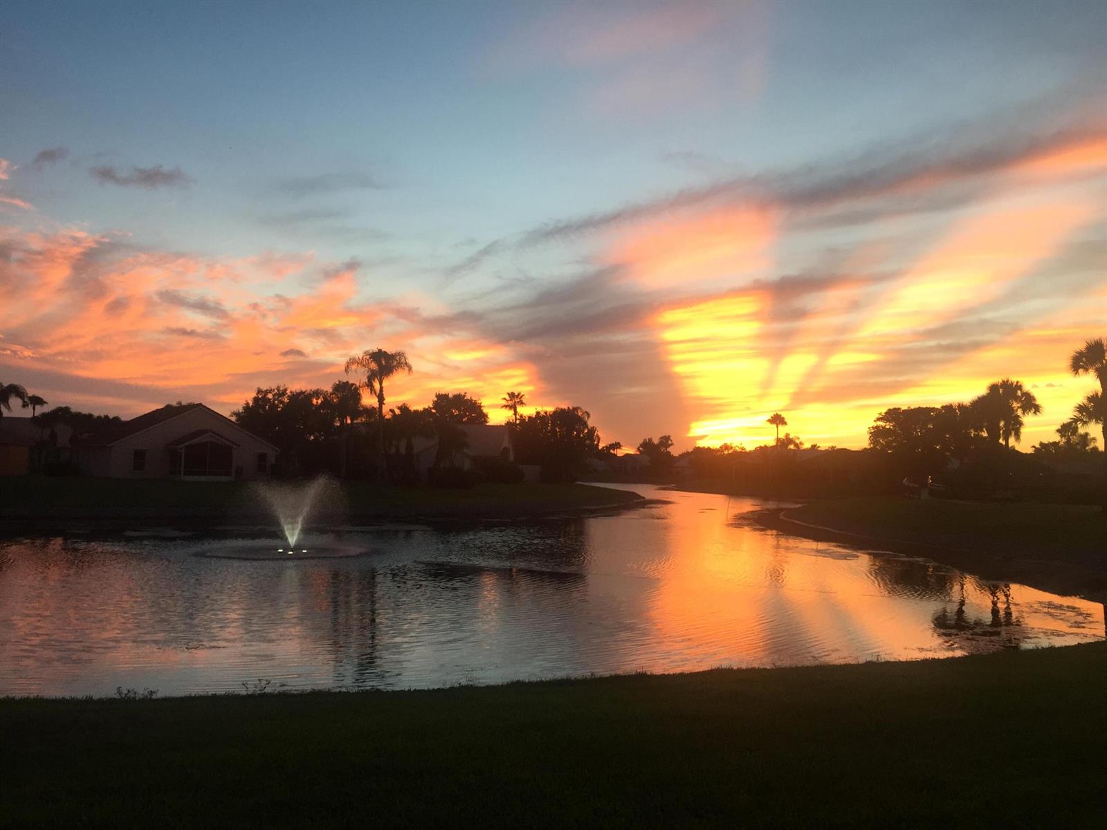 A sunset view over a pond with a fountain and surrounding houses and palm trees — 7777 Stirling Bridge Boulevard S, Delray Beach FL 33446, DELRAY BEACH, FL