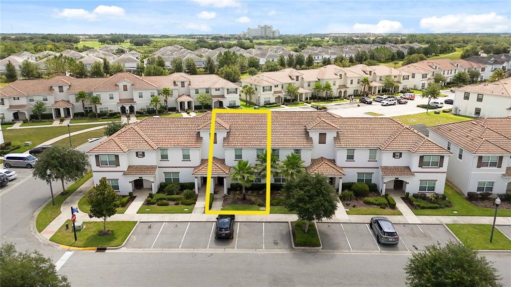 An aerial view shows a two-story townhouse unit highlighted in yellow within a residential complex — 1555 SANDBAGGER DRIVE, DAVENPORT, FL