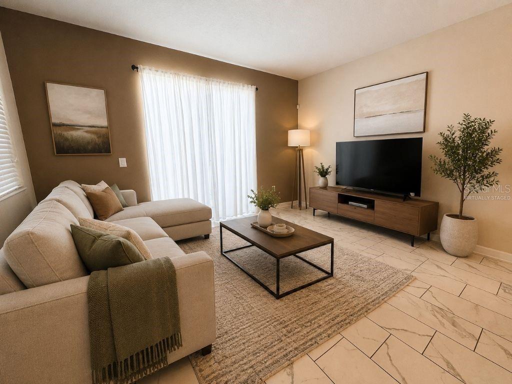 This living room features a sectional sofa, a television on a console, and tiled floors — 1555 SANDBAGGER DRIVE, DAVENPORT, FL