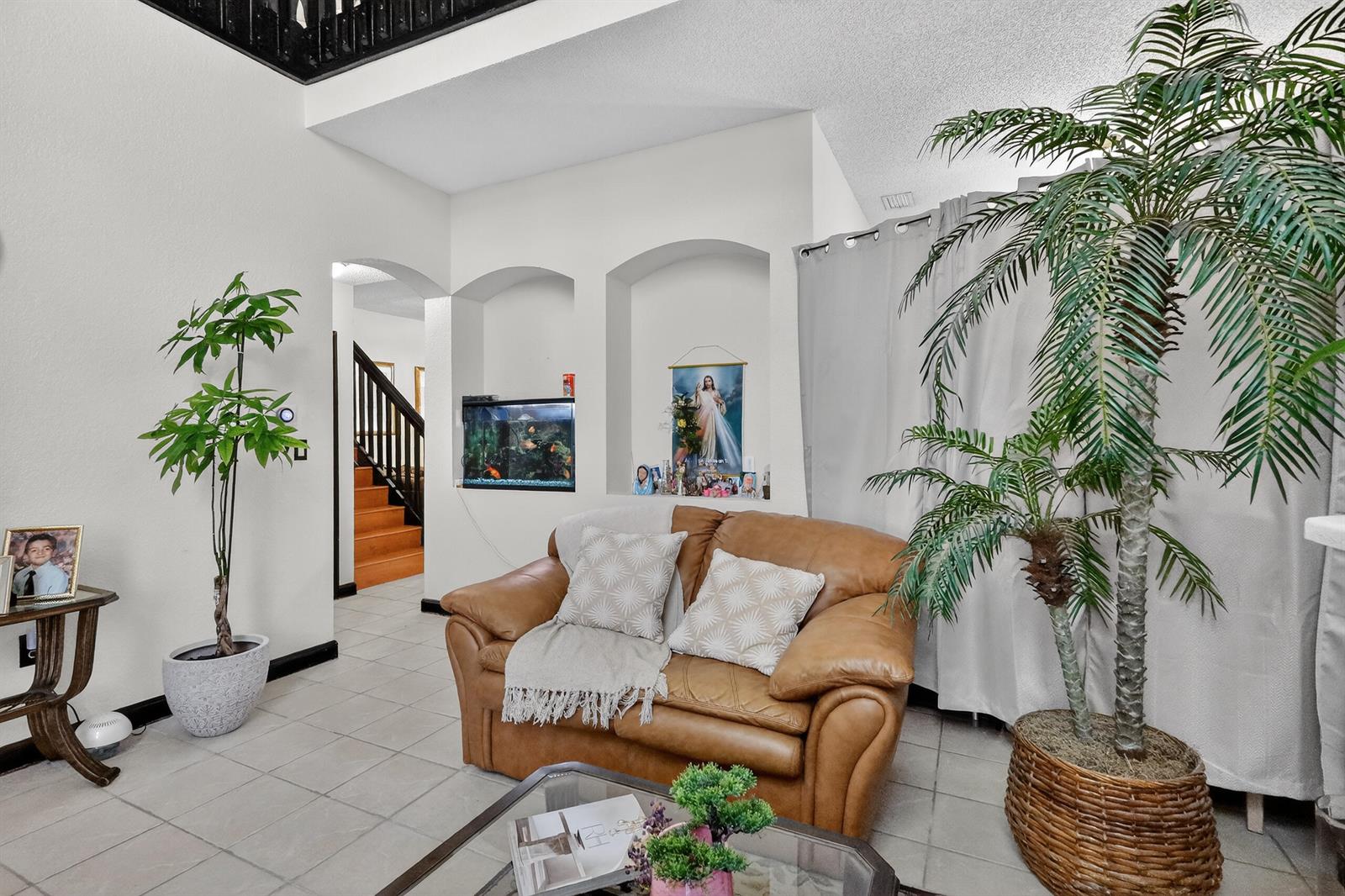 A living room features a tan leather loveseat, two potted plants, and two wall niches — 16266 SW 103rd Terrace, Miami FL 33196, MIAMI, FL