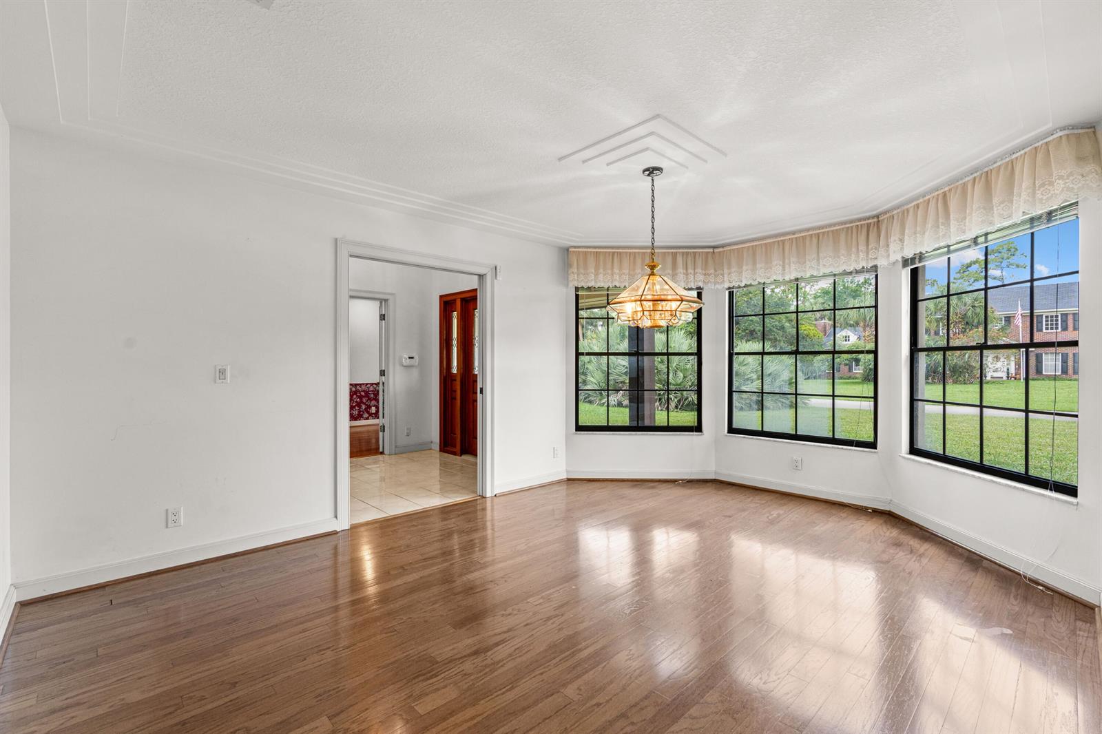 An empty dining room features hardwood floors, a bay window, and a hanging light fixture — 3693 Valley Park Way, Lake Worth FL 33467, LAKE WORTH, FL