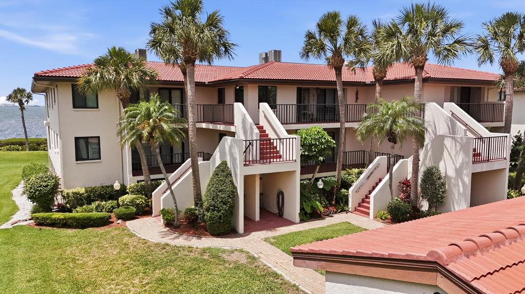 A swimming pool with lounge chairs overlooks a sunset view of the water — 3460 WILD OAK BAY BOULEVARD UNIT 143, BRADENTON, FL