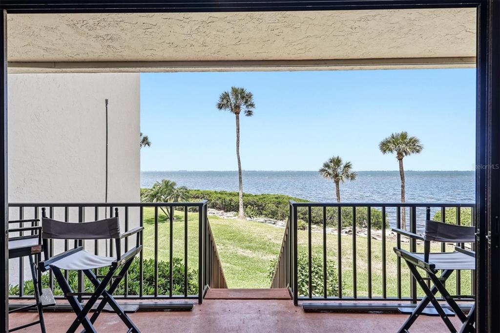 An elevated view of a rectangular swimming pool and hot tub overlooking a large body — 3460 WILD OAK BAY BOULEVARD UNIT 143, BRADENTON, FL