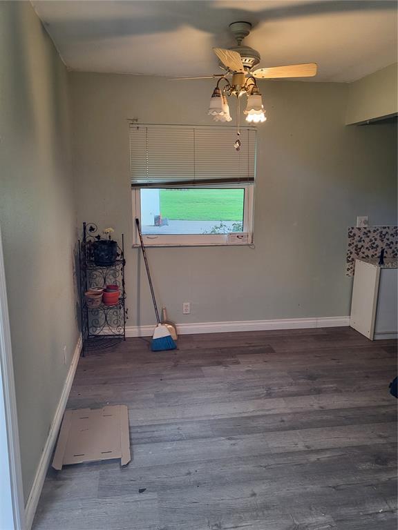A dining area with light green walls, wood-look flooring, a ceiling fan, and a window — 202 BEDFORD TRAIL UNIT 97, SUN CITY CENTER, FL