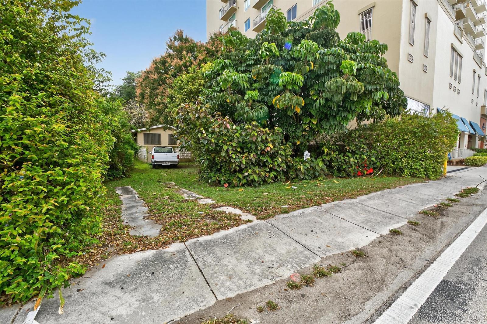 A white pickup truck is parked on a grassy lot next to a large tree — 975 SW 37th Avenue, Miami FL 33135, MIAMI, FL
