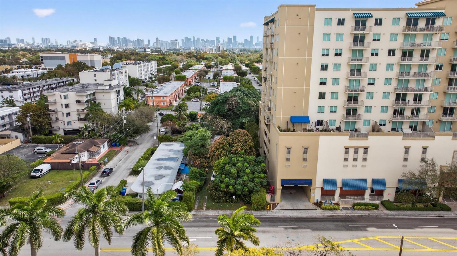 An aerial view shows a tall apartment building next to a street with palm trees — 975 SW 37th Avenue, Miami FL 33135, MIAMI, FL