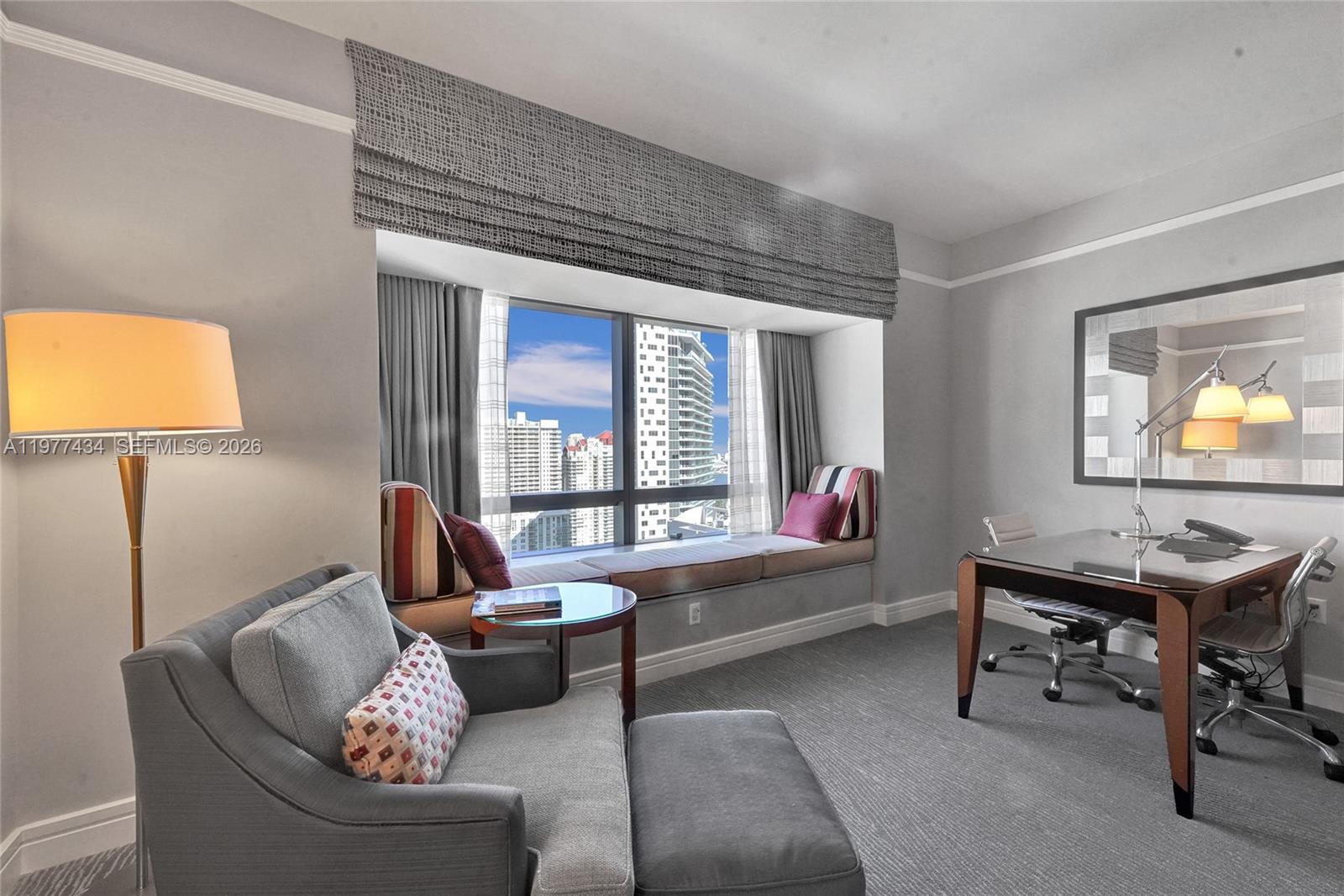 A furnished home office features a window seat, a desk, and a gray armchair — 1435 Brickell Ave # 3308, Miami FL 33131, MIAMI, FL