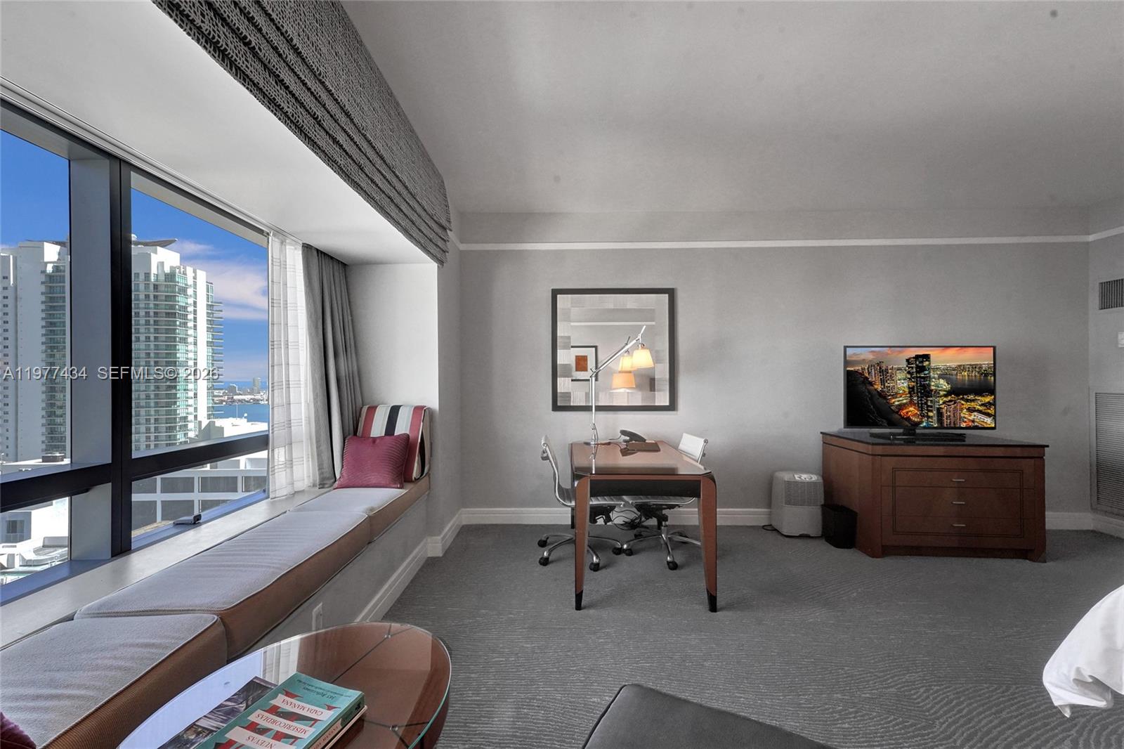 A hotel room features a window seat, a desk, a television, and a city view — 1435 Brickell Ave # 3308, Miami FL 33131, MIAMI, FL