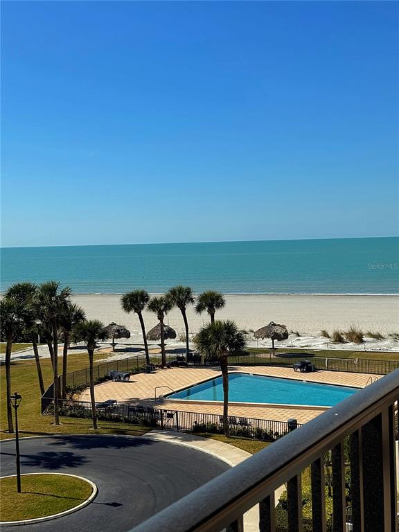 An elevated view of a swimming pool, palm trees, sandy beach, and the ocean — 1460 GULF BOULEVARD UNIT 411, CLEARWATER BEACH, FL