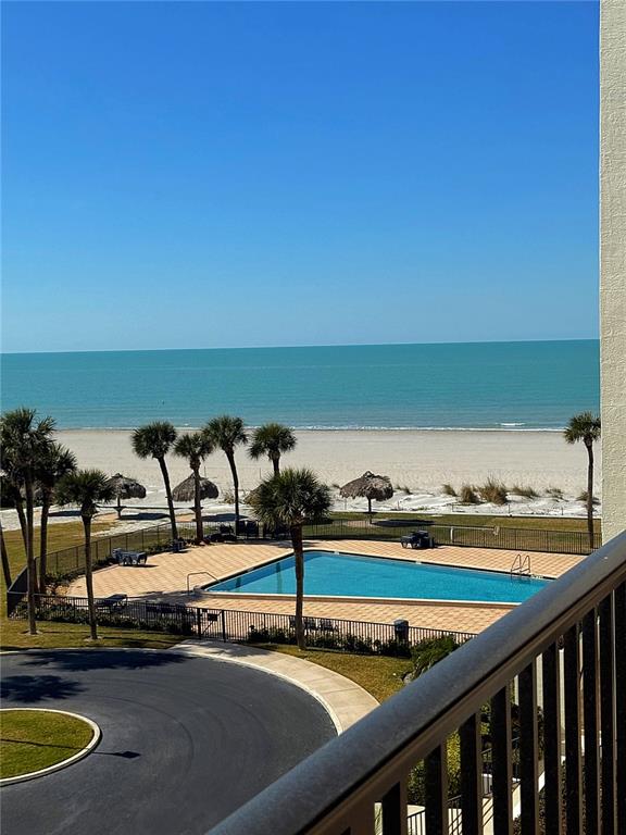 An elevated view shows a swimming pool, palm trees, and a sandy beach by the ocean — 1460 GULF BOULEVARD UNIT 411, CLEARWATER BEACH, FL