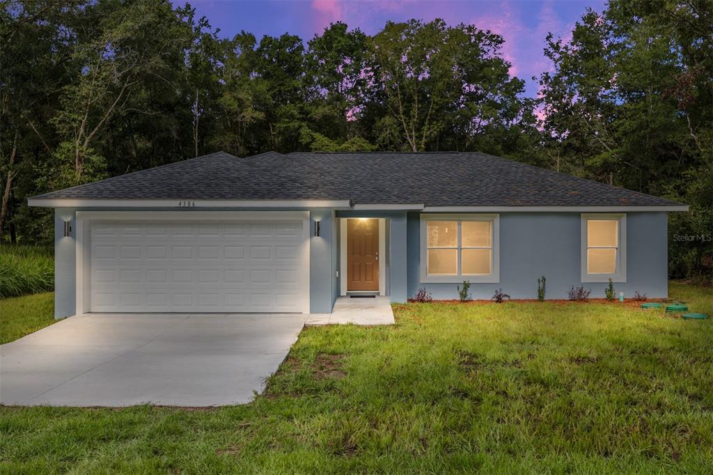 A single-story house with a blue exterior, a two-car garage, and a front entrance — 2110 SW 159TH COURT, OCALA, FL