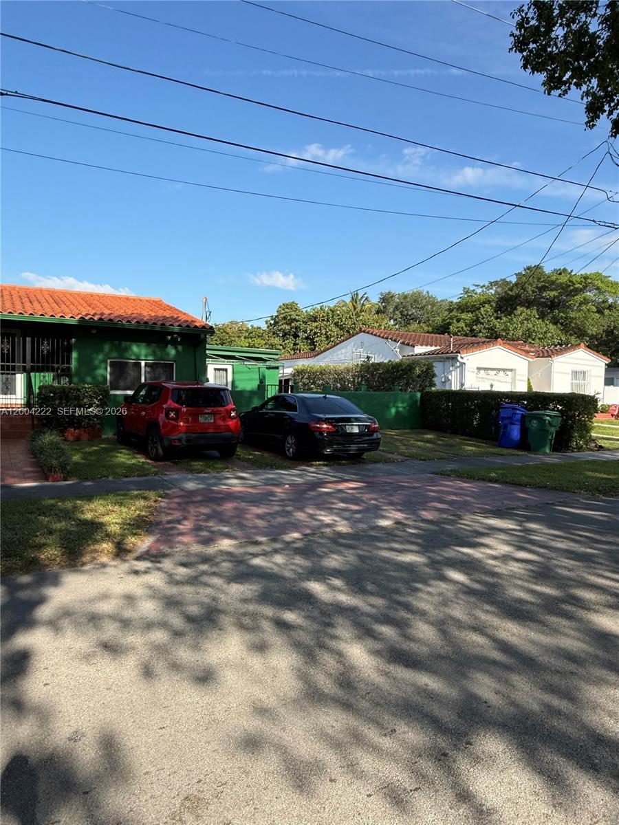 A green house and a white house sit side-by-side with cars parked in their driveways — 540 SW 39th Ave, Coral Gables FL 33134, CORAL GABLES, FL