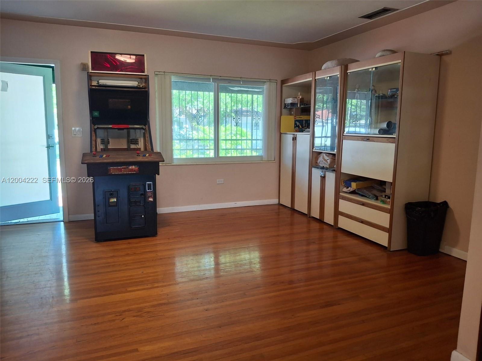A room with hardwood floors, an arcade cabinet, and a large storage unit — 540 SW 39th Ave, Coral Gables FL 33134, CORAL GABLES, FL